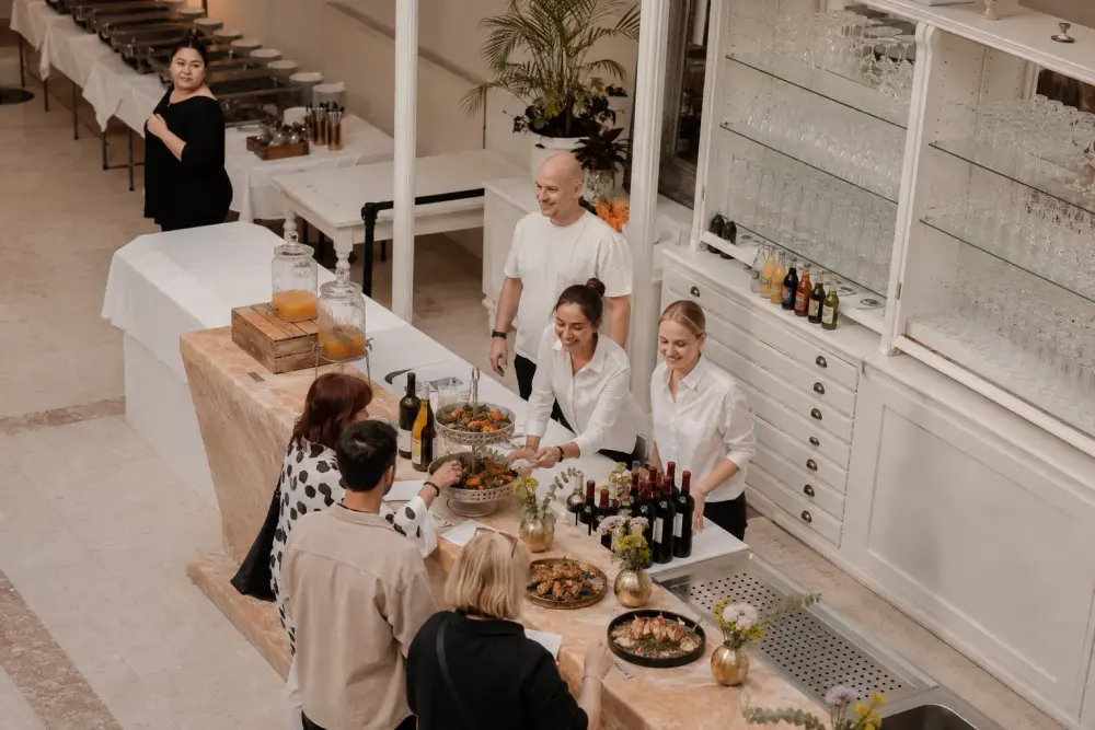 Gäste am Buffet, dahinter das Melavie-Serviceteam